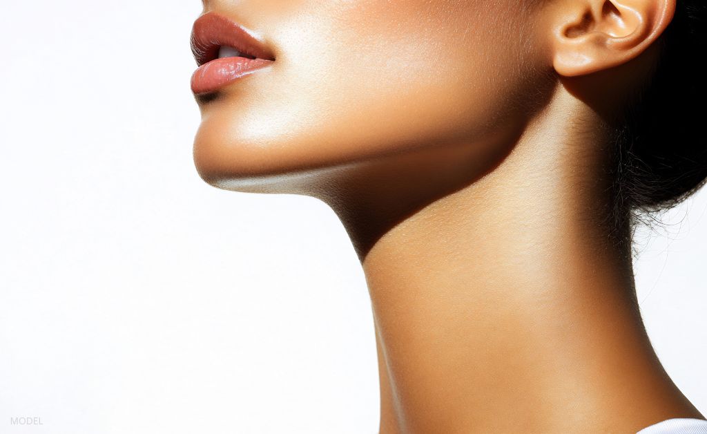 A close-up of a woman's defined chin from the side. (Model)