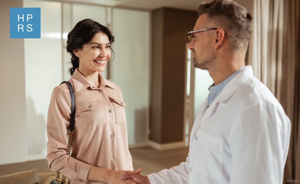 Woman shaking hands with a plastic surgeon (models)